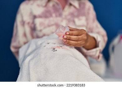 Young African American Woman Pouring Detergent On Clothes At Laundry