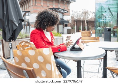 a young african american woman in a red coat cheking bill after shopping - Shutterstock ID 2279706149