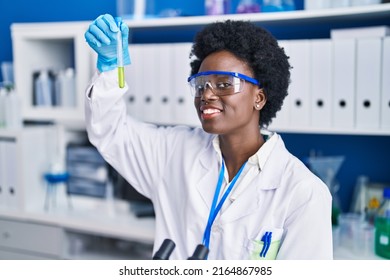 Young African American Woman Scientist Measuring Liquid At Laboratory