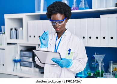 Young African American Woman Scientist Reading Document At Laboratory