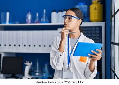 Young african american woman scientist using touchpad with doubt expression at laboratory - Powered by Shutterstock