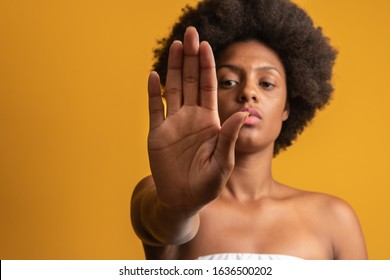 Young African American Woman Shown Hand On Sign For Them To Stop With Racial Prejudice.