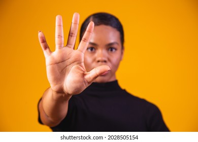 Young African American Woman Shown Hand On Sign For Them To Stop With Racial Prejudice.