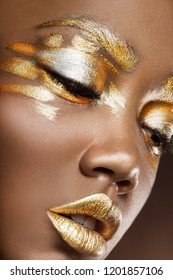 Young African American woman with silver and gold make-up on a black background
