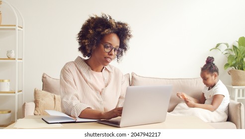 Young African American Woman, Single Mom Working On Laptop Online At Home