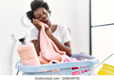 Young African American Woman Smelling Clothes Doing Laundry At Laundry