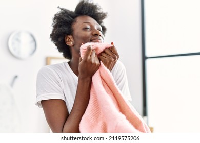 Young African American Woman Smelling Clothes Doing Laundry At Laundry