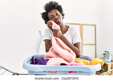 Young African American Woman Smelling Clothes Doing Laundry At Laundry