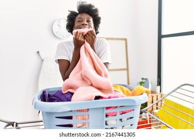 Young African American Woman Smelling Clothes Doing Laundry At Laundry