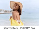 Young african american woman smiling confident wearing summer hat and bikini at beach