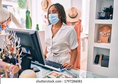 Young African American Woman Smiling Happy Working At The Till Wearing Coronavirus Safety Mask At Retail Shop