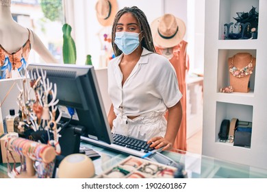 Young African American Woman Smiling Happy Working At The Till Wearing Coronavirus Safety Mask At Retail Shop