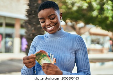 Young African American Woman Smiling Happy Counting South Africa Rand Banknotes At The City.