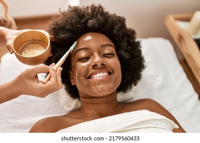 Young african american woman smiling confident having facial treatment at beauty center - Shutterstock ID 2179560433