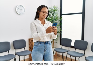 Young african american woman smiling confident using smartphone at waiting room - Powered by Shutterstock