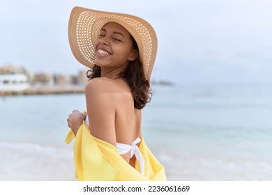 Young african american woman smiling confident wearing summer hat and bikini at beach - Powered by Shutterstock