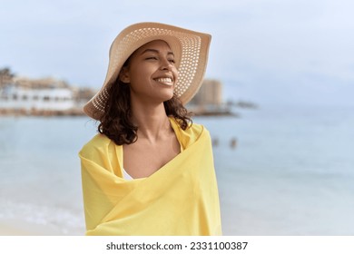 Young african american woman smiling confident wearing summer hat and bikini at beach - Shutterstock ID 2331100387