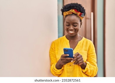 Young african american woman smiling confident using smartphone at street - Powered by Shutterstock