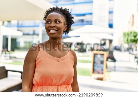 Young african american woman smiling happy at bar terrace on a summer day