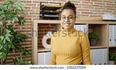 Young african american woman smiling confident wearing glasses at office