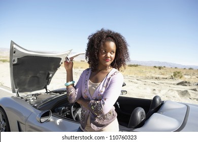 Young African American Woman Standing By Car And Looking For Help