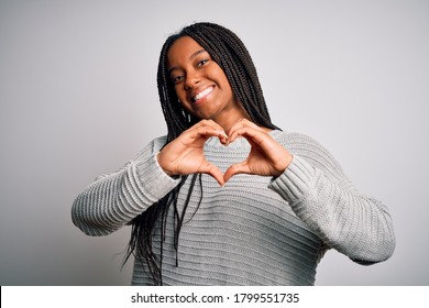 Young african american woman standing casual and cool over grey isolated background smiling in love showing heart symbol and shape with hands. Romantic concept.
