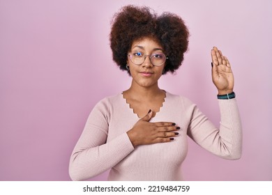 Young African American Woman Standing Over Pink Background Swearing With Hand On Chest And Open Palm, Making A Loyalty Promise Oath 