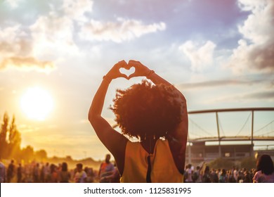 Young African American Woman At Summer Holi Festival Make Heart Symbol By Hands, Back View