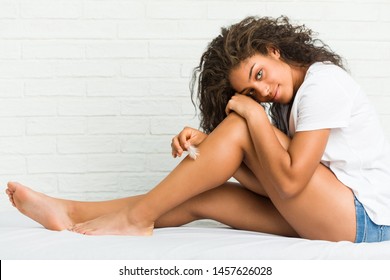 Young african american woman taking care of her legs skin