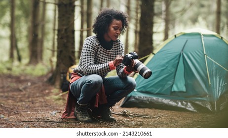 Young African American Woman Taking Photos With A Telephoto Lens While Camping In The Woods With Friends 