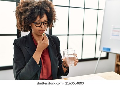 Young African American Woman Taking Pill At Office