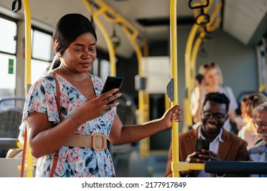 A young african american woman is texting on her smartphone while riding the shuttle bus - Powered by Shutterstock