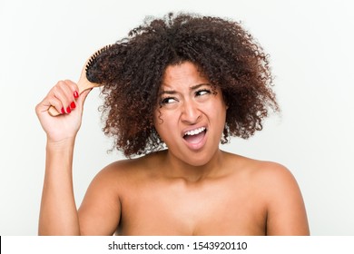 Young African American Woman Trying To Brush Her Curly Hair