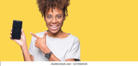 Young african american woman using smartphone over isolated background very happy pointing with hand and finger