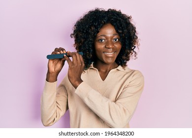 Young African American Woman Using File Nail Looking Positive And Happy Standing And Smiling With A Confident Smile Showing Teeth 