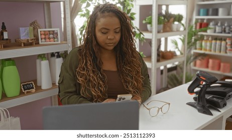 Young african american woman using smartphone in home decor store with shelves of colorful products in the background. - Powered by Shutterstock