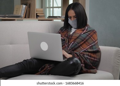 Young African American Woman Wearing Medical Mask And Warm Plaid Using Laptop During Remotely Work At Home Due To Coronavirus Pandemic. Stay Home Remotely Office Coronavirus Social Distancing