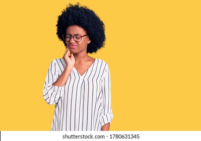 Young african american woman wearing casual clothes and glasses touching mouth with hand with painful expression because of toothache or dental illness on teeth. dentist 