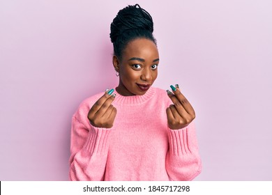 Young African American Woman Wearing Casual Winter Sweater Doing Money Gesture With Hands, Asking For Salary Payment, Millionaire Business 