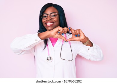 Young african american woman wearing doctor stethoscope smiling in love showing heart symbol and shape with hands. romantic concept.  - Powered by Shutterstock