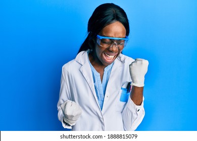 Young African American Woman Wearing Scientist Uniform Celebrating Surprised And Amazed For Success With Arms Raised And Eyes Closed 