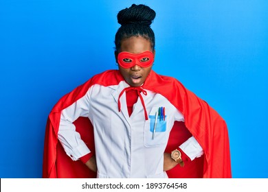 Young African American Woman Wearing Doctor Uniform And Super Hero Costume Afraid And Shocked With Surprise And Amazed Expression, Fear And Excited Face. 