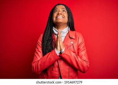 Young African American Woman Wearing Cool Fashion Leather Jacket Over Red Isolated Background Begging And Praying With Hands Together With Hope Expression On Face Very Emotional And Worried. Begging.