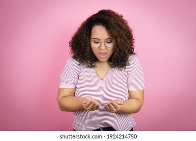 Young African American Woman Wearing Red Stripes T-shirt Over Pink Background Smiling With Hands Palms Together Receiving Or Giving Gesture. Hold And Protection