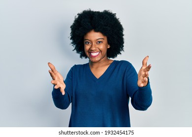 Young african american woman wearing casual clothes looking at the camera smiling with open arms for hug. cheerful expression embracing happiness. 