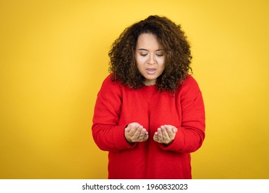 Young African American Woman Wearing Red Sweater Over Yellow Background Smiling With Hands Palms Together Receiving Or Giving Gesture. Hold And Protection