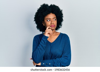 Young african american woman wearing casual clothes thinking concentrated about doubt with finger on chin and looking up wondering 