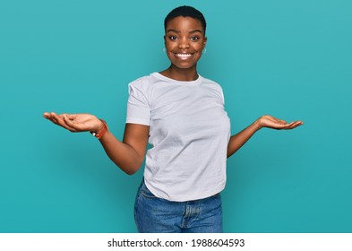 Young african american woman wearing casual white t shirt smiling showing both hands open palms, presenting and advertising comparison and balance 