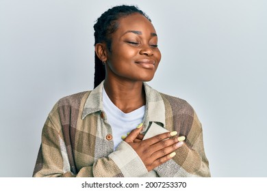 Young african american woman wearing casual clothes smiling with hands on chest, eyes closed with grateful gesture on face. health concept. 