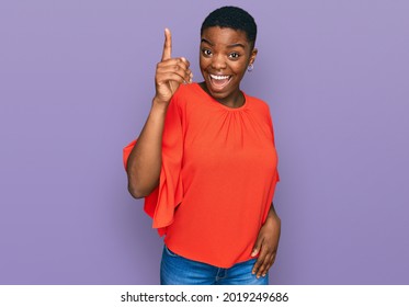 Young african american woman wearing casual clothes pointing finger up with successful idea. exited and happy. number one.  - Shutterstock ID 2019249686